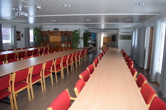 Salen med bord og stoler. Sett fra scenen.